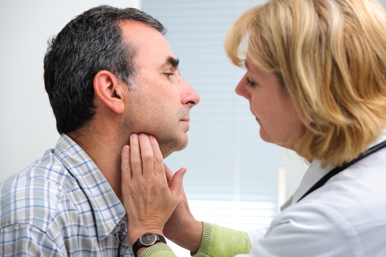 throat-cancer-exam Female doctor performing an exam on a male patient's throat.